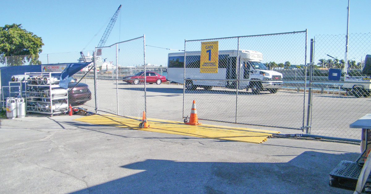 Cable protectors line the ground in front of fencing at an event site